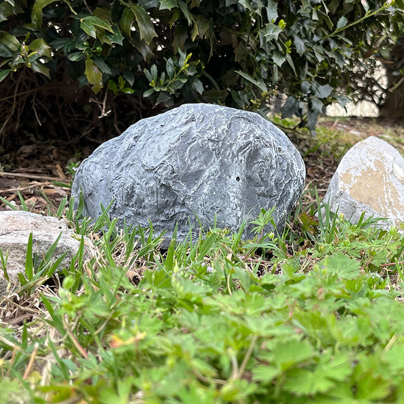 Xtreme Life 4K Solar Rock positioned in garden for stealth monitoring
